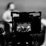 Camera capturing an indoor interview scene, in focus with a blurred background.