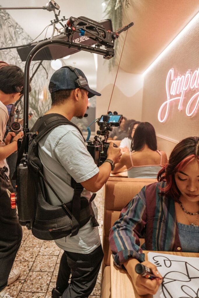 Candid scene of a filmmaker recording in a vibrant café environment.